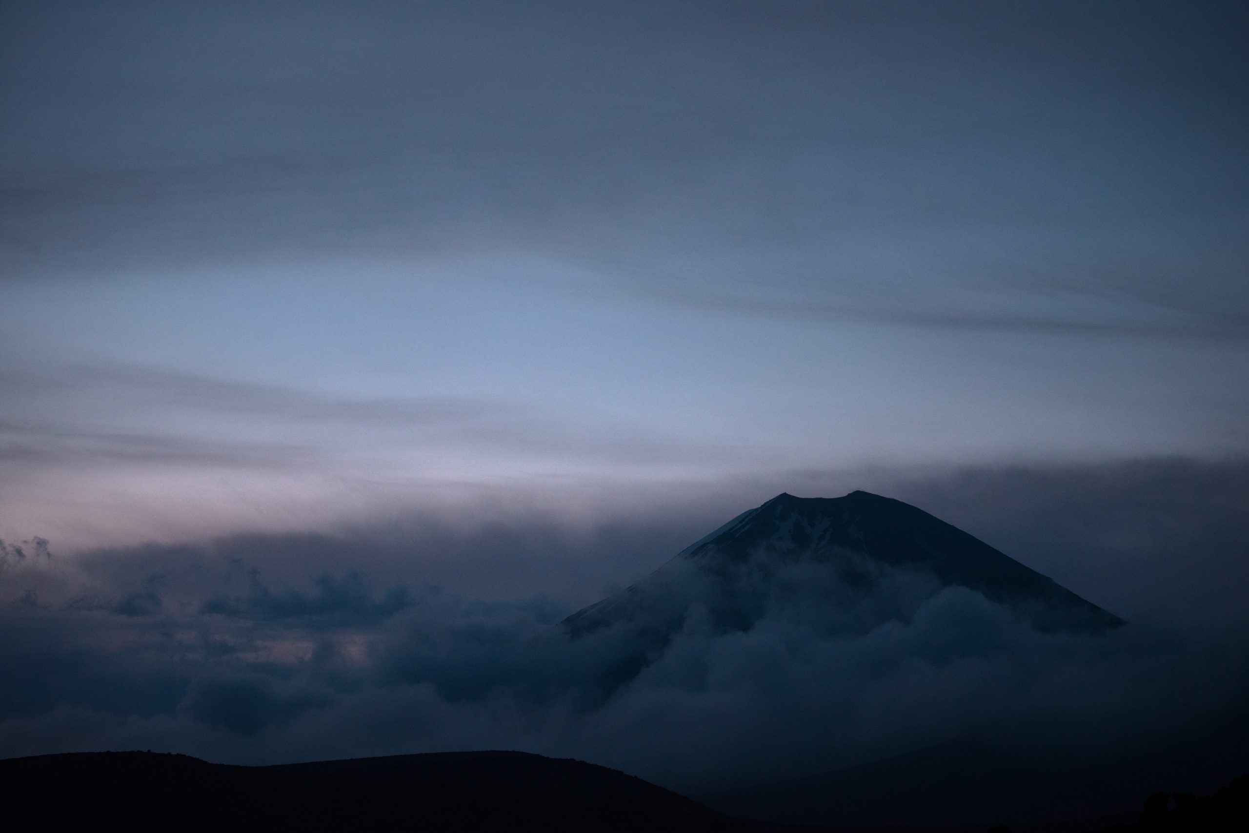 Mount Ngauruhoe pokes through the clouds right after sunset